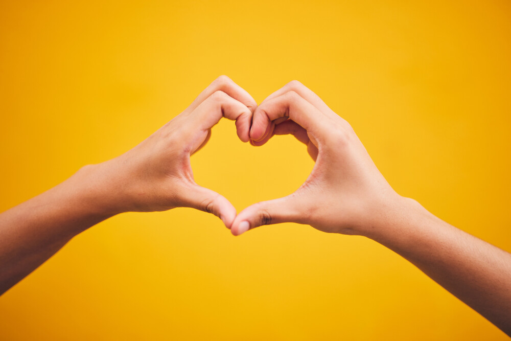 Heart hands and person in studio